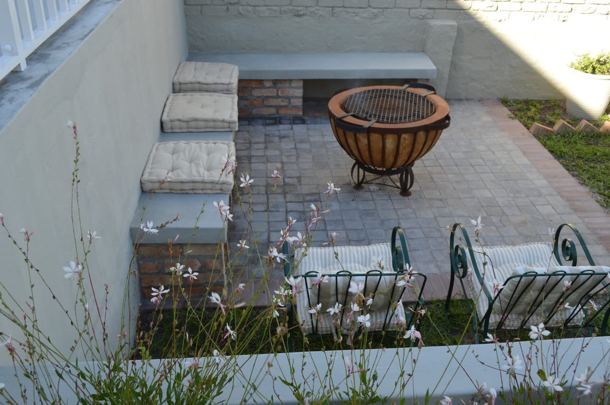 The garden seating area framed by white flowering plants